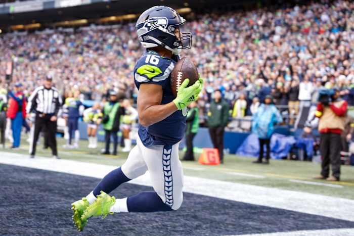 Tyler Lockett is in the air with the ball in his hands